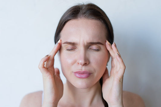 Person holding their head with eyes closed — magnesium for migraines and headaches