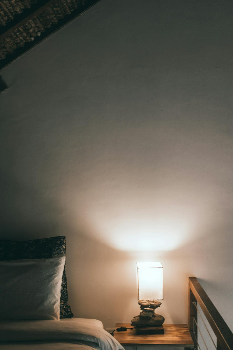 Dormitorio acogedor con lámpara cálida — beneficios de la ashwagandha