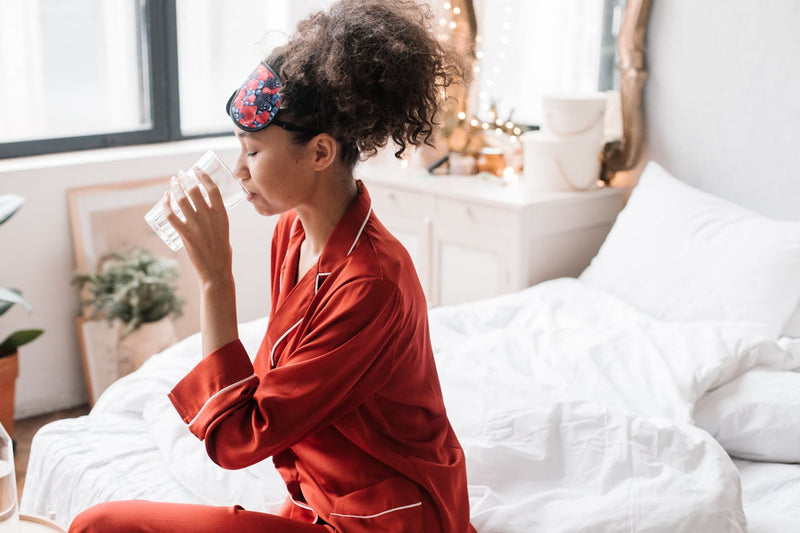 Woman drinking a glass of water — magnesium supplement for women, sleep and stress