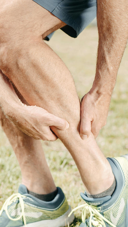 Person holding their calf — magnesium for leg cramps and eye twitching